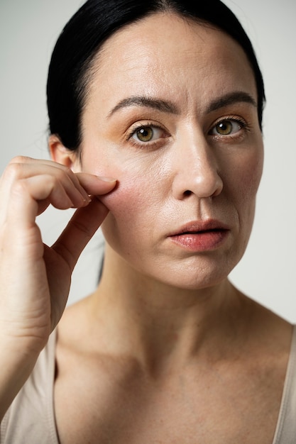 Brunette woman holding her cheek