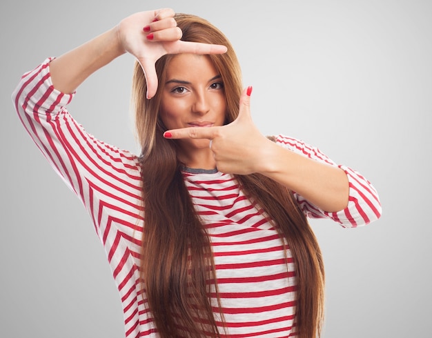 Brunette woman showing gesture like frame.