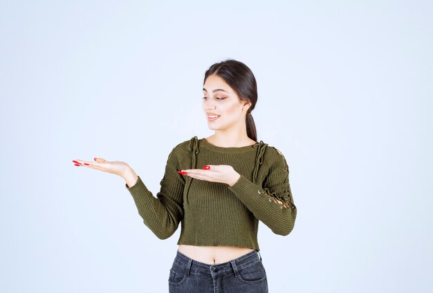 brunette woman showing open space on white background.