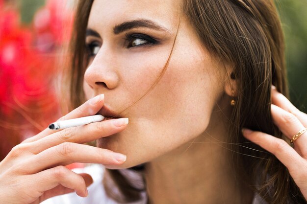 Brunette woman smokes a cigar