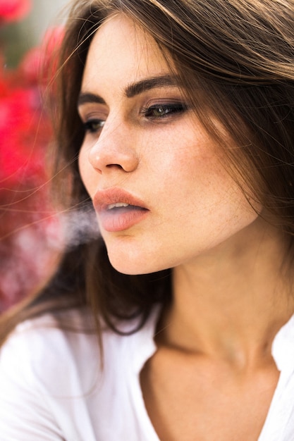 Brunette woman smokes a cigar