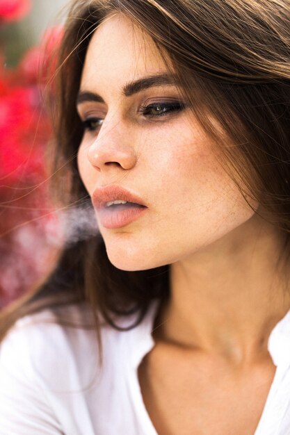 Brunette woman smokes a cigar