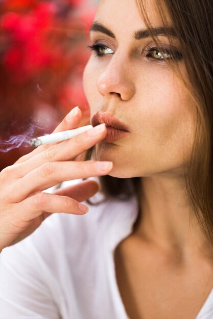 Brunette woman smokes a cigar
