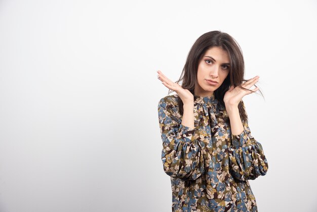 Brunette woman standing on a white background. 