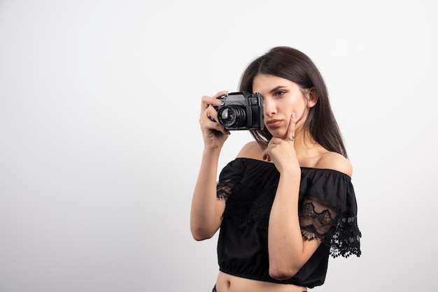 Брюнетка женщина фотографирует с камерой