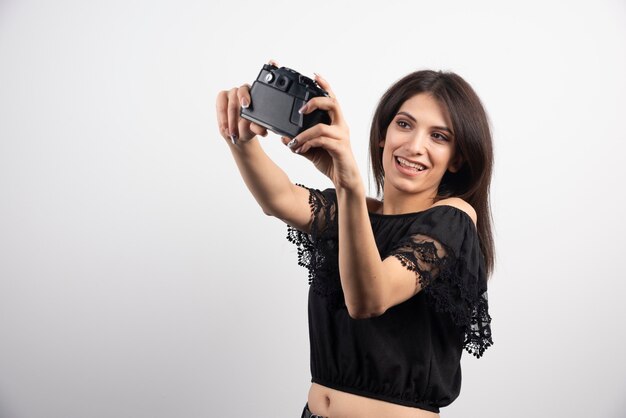 Brunette woman taking selfies with camera