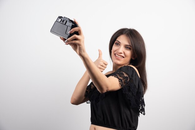 Brunette woman taking selfies with camera