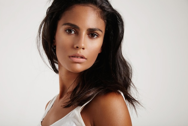 Brunette woman watching at camera on a white background