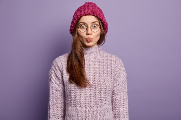 Брюнетка женщина в вязаном свитере и шляпе