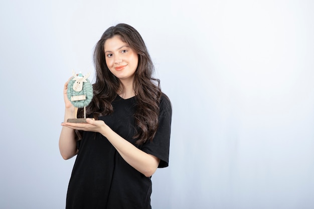 Brunette woman with long hair holding deer toy and posing .