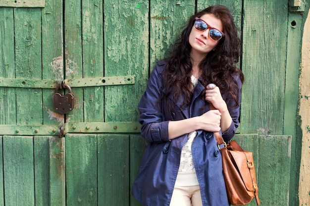 Free photo brunette woman with sunglasses holding her brown handbag