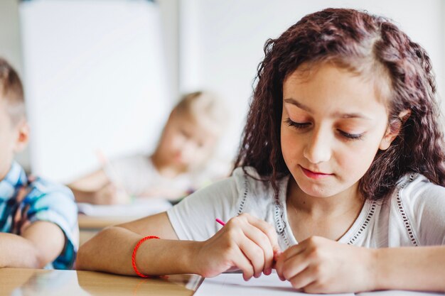 Brunette young girl sitting at desk