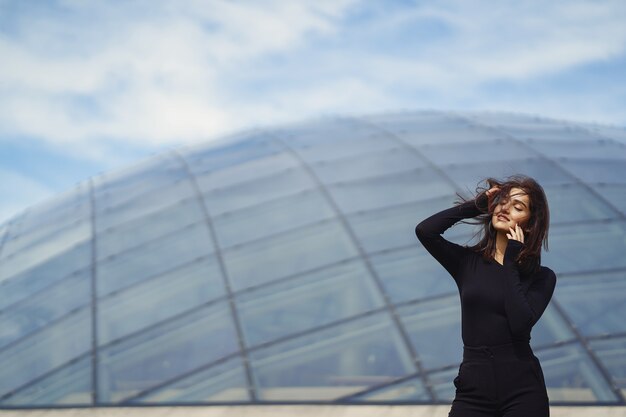 brunetter girl next to a modern building