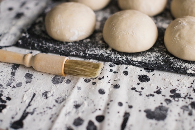 Brush near the uncooked bread on slate with flour