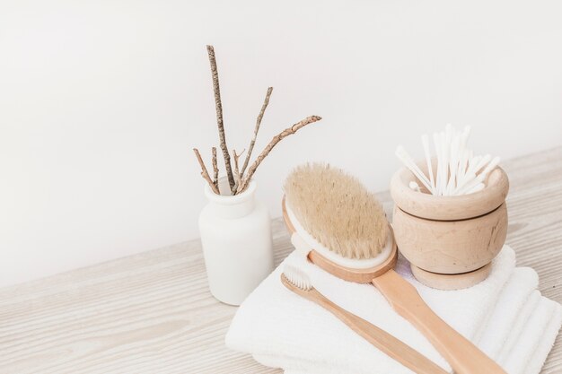 Brush; towel and cotton swabs on wooden surface