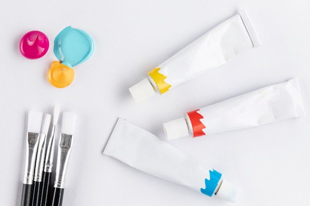 Free photo brushes and paint tubes on white table