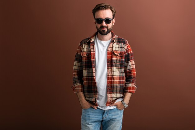 Brutal hipster handsome stylish bearded man on brown