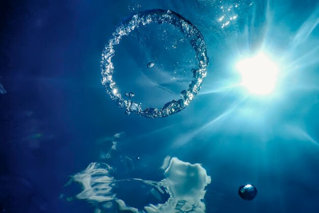 Пузырьковое кольцо под водой поднимается к Солнцу.