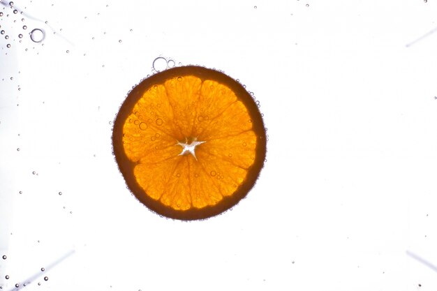 무료 사진 거품 물에 떠있는 신선한 오렌지 슬라이스를 커버