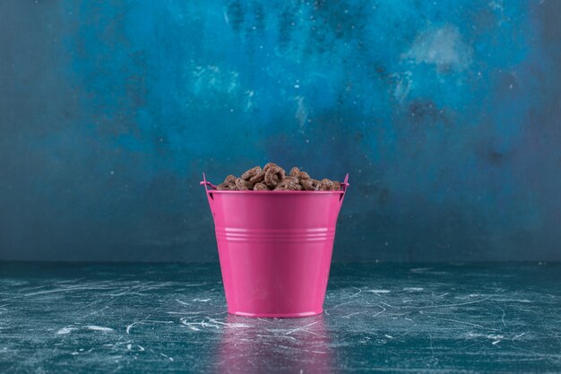 A bucket of corn rings , on the blue background. High quality photo