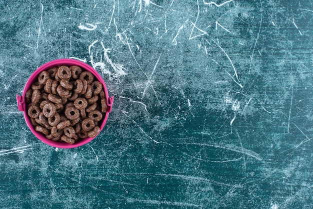 A bucket of corn rings , on the blue table. 