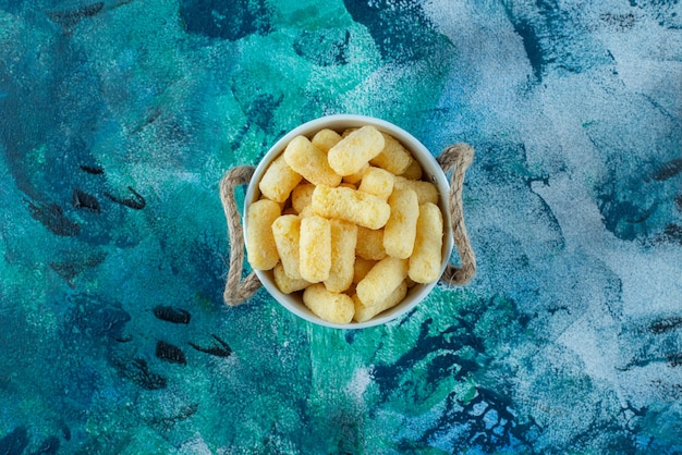 A bucket of corn sticks , on the marble table.