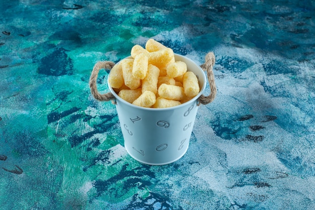 A bucket of corn sticks , on the marble table.