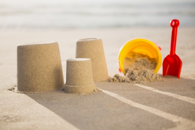 Bucket, spade and sand castles on beach