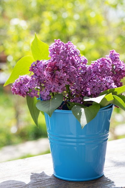 Free photo bucket with a branch of lilac flower