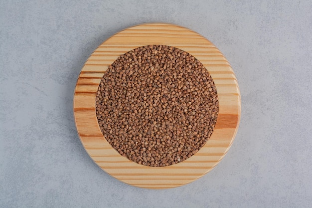 Бесплатное фото Гречка с горкой на деревянной тарелке на мраморной поверхности