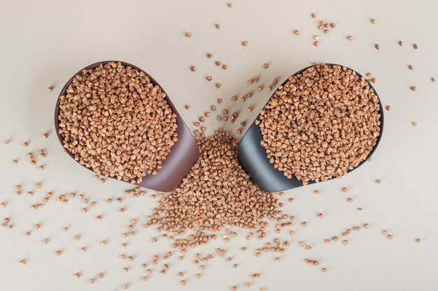 Buckwheat seeds in a cup on concrete.