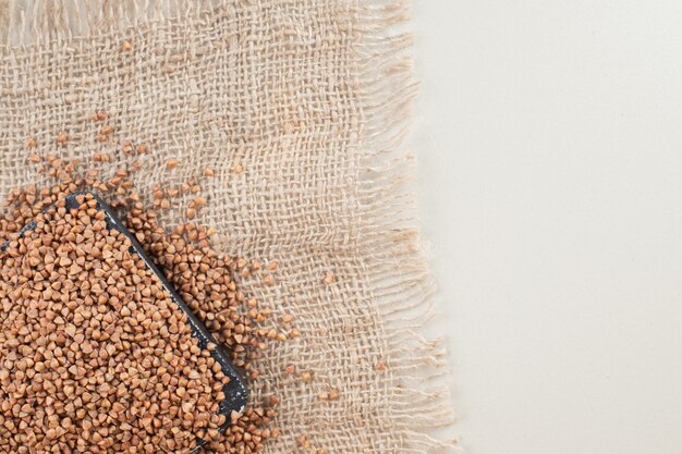 Buckwheat seeds in a dish on concrete.