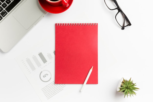 Budget chart,spiral notepad,pencil,cactus plant,laptop and eyeglasses on white background