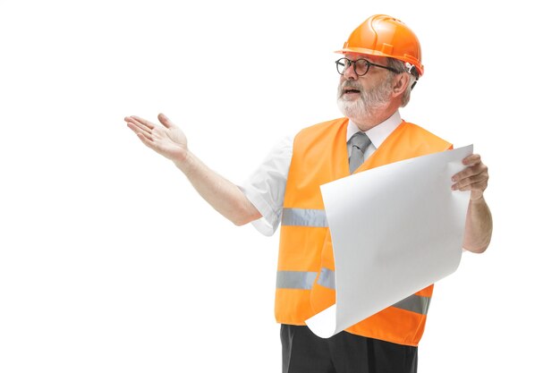 Строитель в жилете строительства и оранжевом шлеме, стоящем на белом.