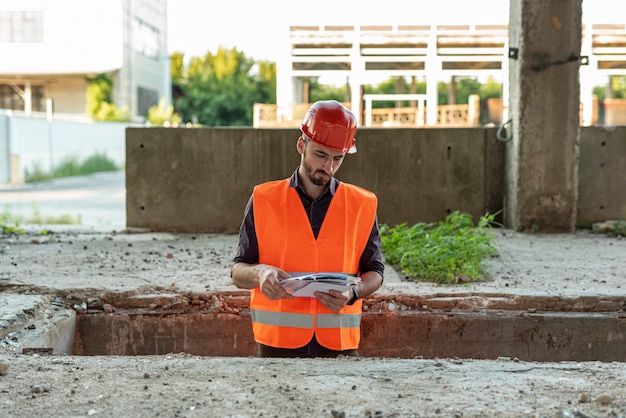 Builder looking at documents on construction site