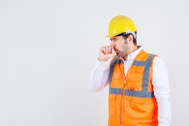 Builder man suffering from flu in shirt, uniform and looking sick. front view.