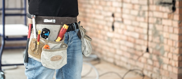 Builder with construction tools at construction site