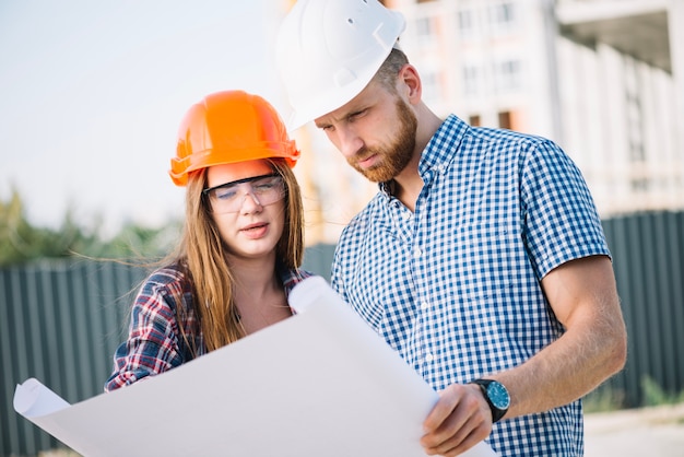 Builder woman and man at blueprint