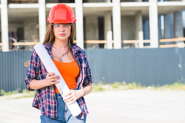 Builder woman standing with blueprint