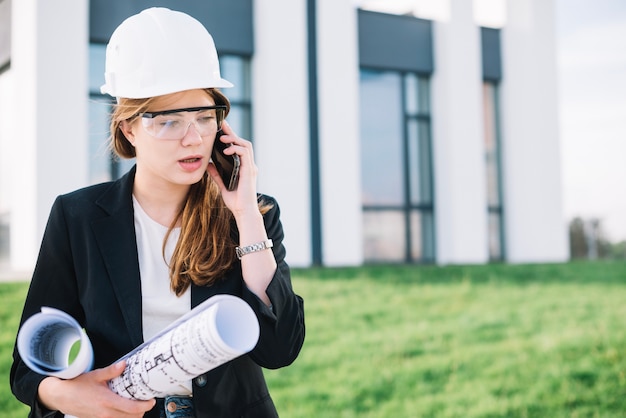 Donna del costruttore che parla sul telefono