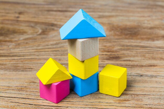 Free photo building blocks on wooden background，colorful wooden building blocks