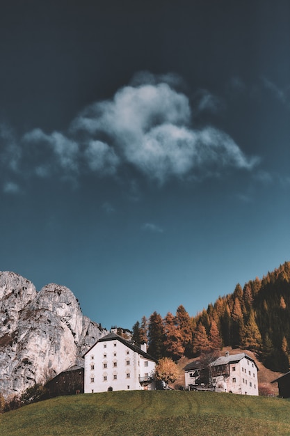 Foto gratuita costruzioni accanto alla montagna sotto il cielo nuvoloso