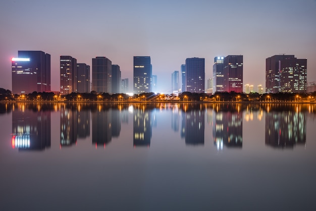 buildings standing by riverside under dramatic sky