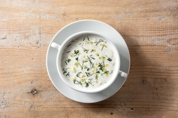 Bulgarian tarator sour milk soup in bowl on wooden table