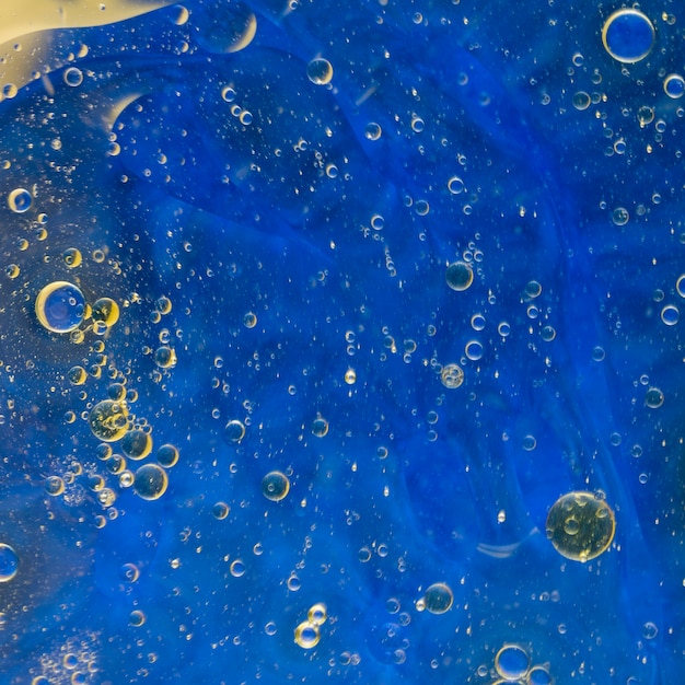 Bulles d'huile flottant sur fond aquarelle bleu