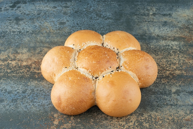 Bun of fresh white bread on marble background