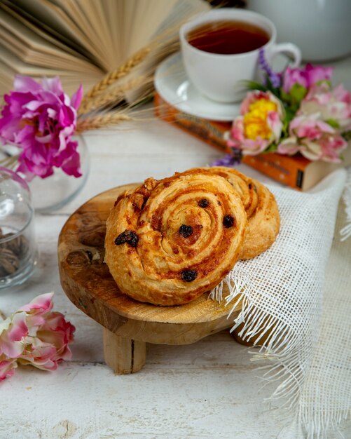 Bun with raisins with cup of black tea