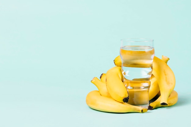 Bunch of bananas behind a glass of water