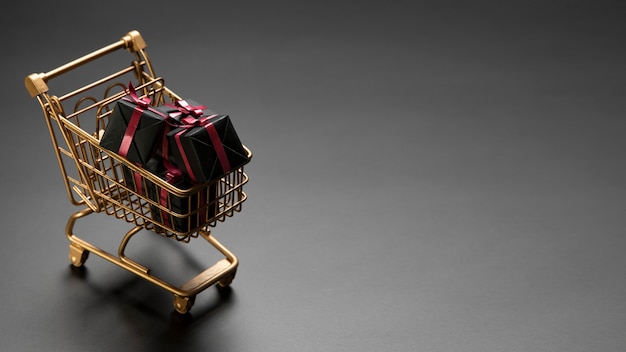 Bunch of black friday gifts in golden shopping cart with copy space