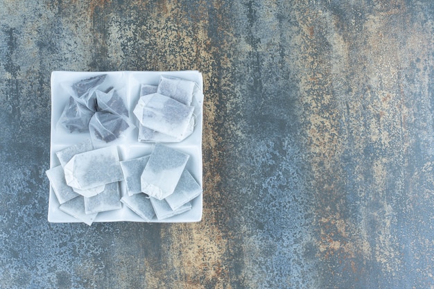 Free photo bunch of black teabags on white plate.